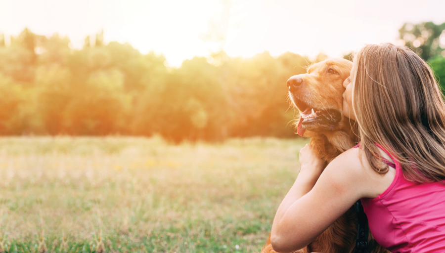 Жена седеше с кучето си навън в полето и целуваше лицето му